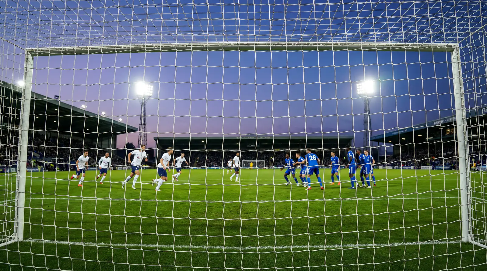 Trailing favourite pushing for equaliser with tactical formation shift visible on pitch