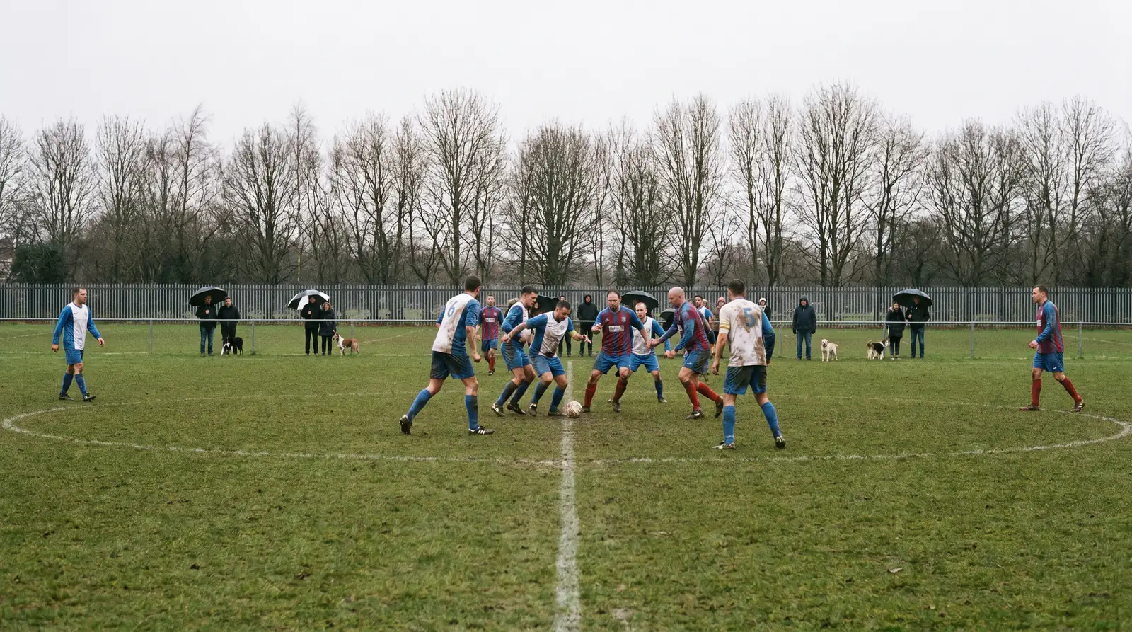 Sunday league football match on a local grass pitch with amateur players competing