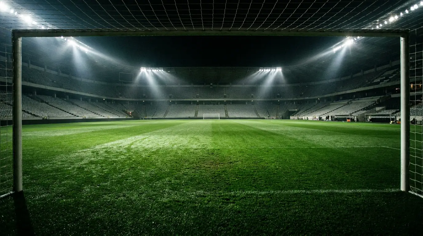 European football stadium pitch under bright floodlights at night